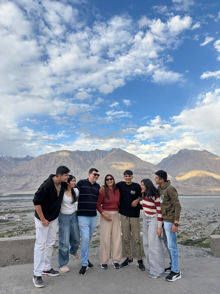 Friends posing in front of a mountain valley